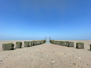 A sign on a breakwater, horizon and a cloudless sky.