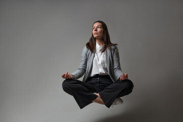 Meditation and stress control at work, a young woman in a business suit, - obrazy, fototapety, plakaty