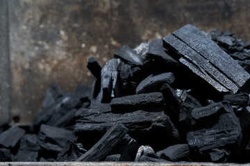 Heap of black grill coal from the side. Close up.