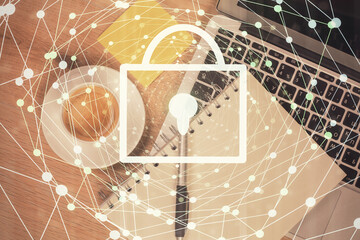 Double exposure of lock hologram drawing over study table background with computer. Concept of data security. Top view.