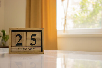 Wooden blocks of the calendar represents the date 25 and the month of October on the background of...