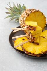 Ripe juicy pineapple cut into rings close-up, pineapple in the form of ice cream on a stick