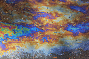 puddle gasoline background, wet oil multicolored rainbow pollution spill