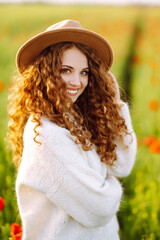 Portrait of beautiful woman in amazing poppy field. Young  woman posing in the blooming poppy field. Nature, vacation, relax and lifestyle. Summer landscape.