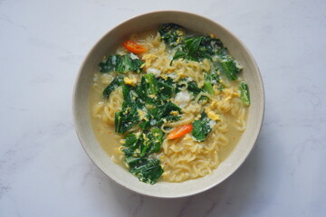 a bowl of noodle soup with vegetables