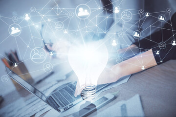 Double exposure of woman hands typing on computer and light bulb drawing. Idea concept.