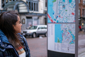 バンクーバーのダウンタウンで街中にある地図を確認するメキシコ人女性