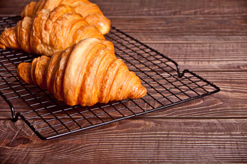 Top view of fresh baked croissants on baking rack.