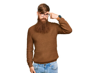 Young irish redhead man wearing casual clothes and glasses pointing unhappy to pimple on forehead,...