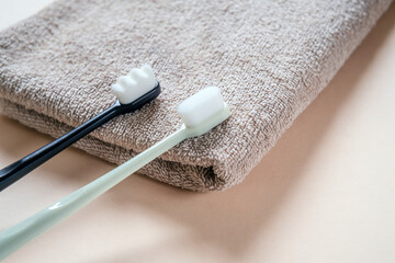 Ultra-fine toothbrushes with soft bristles on a bath towel top view, dental care and hygiene trends
