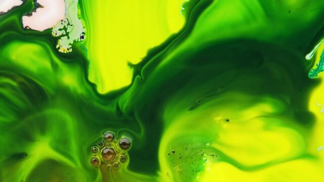 Deep green and yellow inks interact with each other to create abstract shapes, swirls, and splash. Screensaver for advertising or background display colors. Deep ink space.