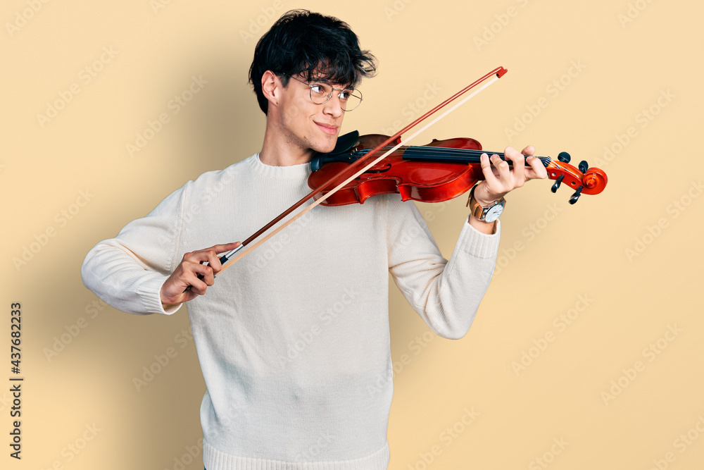 Poster Handsome hipster young man playing violin smiling looking to the side and staring away thinking.