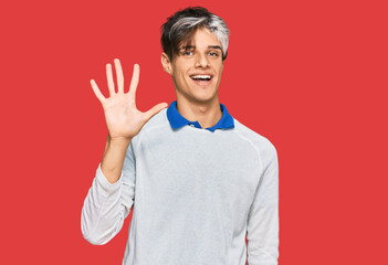 Young hispanic man wearing casual clothes showing and pointing up with fingers number five while smiling confident and happy.