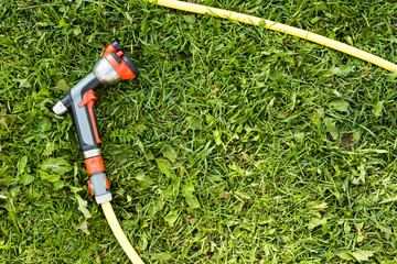 Watering garden hose nozzle on a green grass
