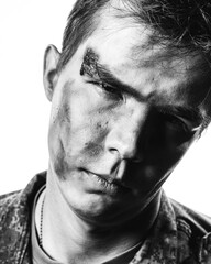 Black and white portrait of a young soldier in uniform and combat coloring with bruises and scars...