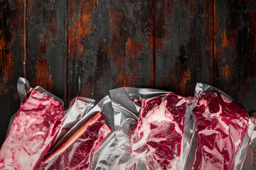 Beef steak vacuum, tomahawk, t bone, club steak, rib eye and tenderloin cuts, on old dark  wooden...