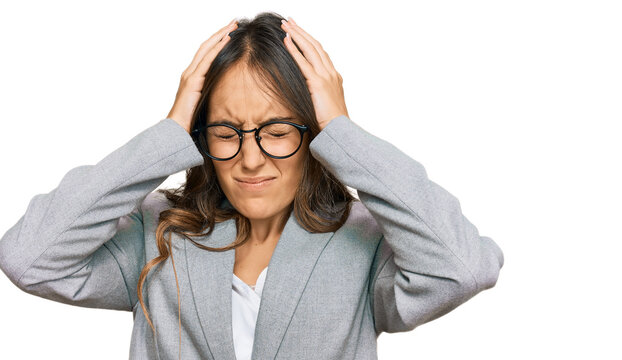 Young brunette woman wearing business clothes suffering from headache desperate and stressed because pain and migraine. hands on head.