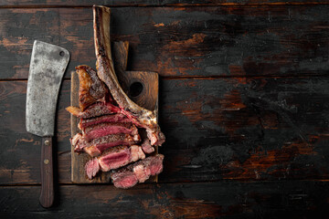 Sliced barbecued tomahawk rib tip with rosemary, salt and herbs medium rare, on wooden serving...