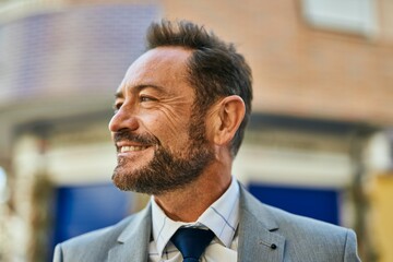 Middle age businessman smiling happy standing at the city.