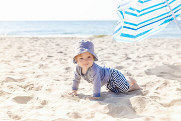 portrait of a boy in a panama hat on the beach. eight month old blonde
