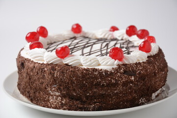 Black forest cake, Schwarzwald pie, dark chocolate and cherry dessert on a white background. Black forest cake decorated with whipped cream and cherries.