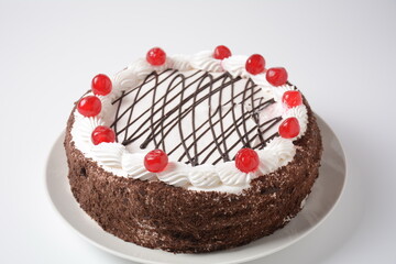 Black forest cake, Schwarzwald pie, dark chocolate and cherry dessert on a white background. Black forest cake decorated with whipped cream and cherries.