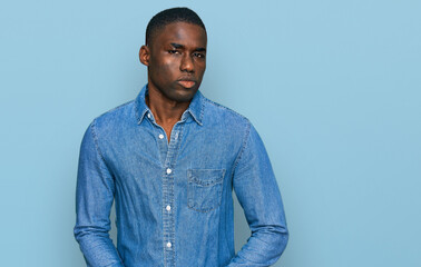 Young african american man wearing casual clothes puffing cheeks with funny face. mouth inflated...