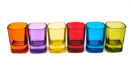 colored empty small glasses on white background
