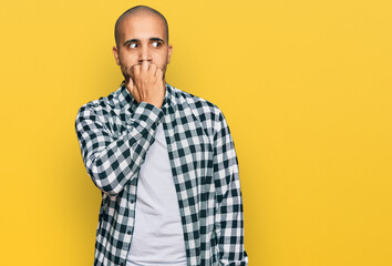 Hispanic adult man wearing casual clothes looking stressed and nervous with hands on mouth biting...