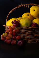 closeup of basket of fruits (mango, grapes)