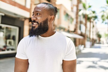 Fototapeta premium Handsome african american man with beard wearing casual white t shirt outdoors on a sunny day