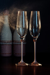 two glasses of champagne on black background