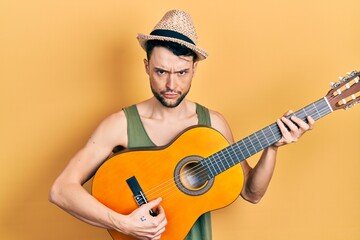 Obraz premium Young hispanic man playing classical guitar skeptic and nervous, frowning upset because of problem. negative person.