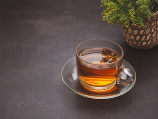 A teacup with flowers placed on a dark background.Space for text. Morning beverage and relaxation concept