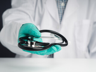 A doctor wearing gloves and holding a stethoscope with copy space for text. Close-up photo. Concept of medical and healthcare