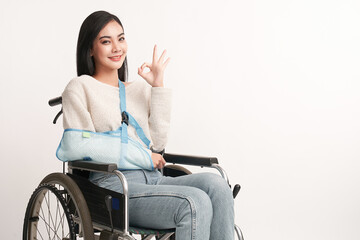 Broken arm Beautiful young asian with happy smiling woman in a wheelchair on white background, healthcare concept, accident, insurance, life insurance, wellness, hospital