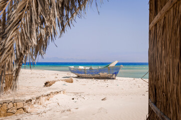 Fototapeta na wymiar old wooden fishing boats resting on the beach of the bay blue lagoon in egypt