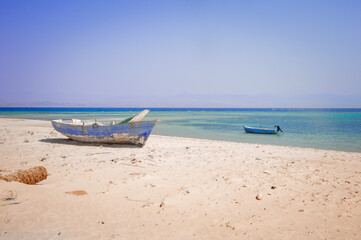 Fototapeta na wymiar old wooden fishing boats resting on the beach of the bay blue lagoon in egypt