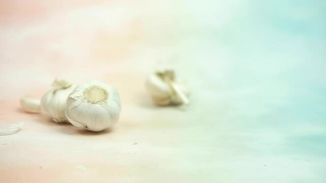 Slow motion and panning of fresh garlic rolling rolling into. Close-up.