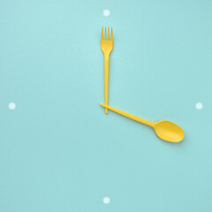 Spoon and fork in the shape of a clock. Lunch time, intermittent fasting concept.
