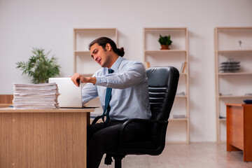 Young male employee unhappy with excessive work