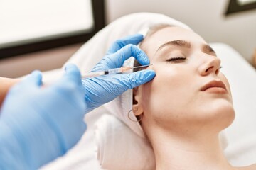 Doctor injecting botox on woman face for anti aging treatment at the clinic.