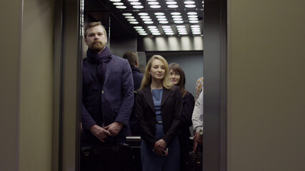 Business executives standing in office building elevator
