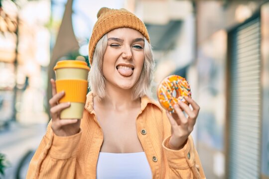 Young blonde girl smiling happy having breakfast at the city.