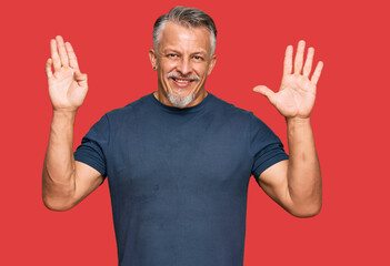 Middle age grey-haired man wearing casual clothes showing and pointing up with fingers number nine...