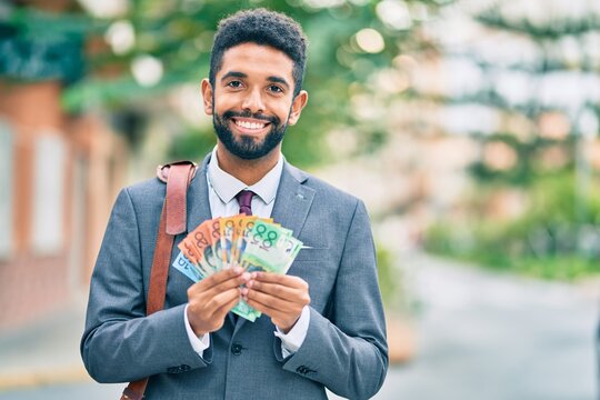 Young african american businessman smiling happy australian dollars banknotes at the city. - Powered by Adobe