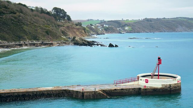 Looe Beach - South East Cornwall in 4K. Looe - coastal town and civil parish in England with multiple old English houses on the cliff and seashore of Looe Bay in the English Channel.