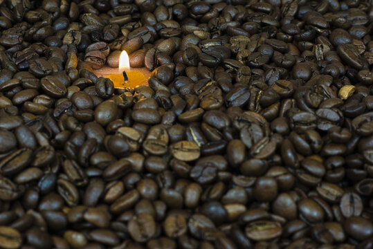 scattered coffee beans in the background a small candle