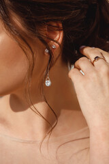 Beautiful earrings with diamonds on a girl with dark blond hair