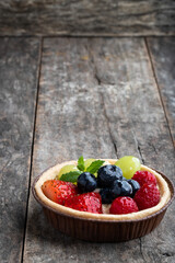 Fresh fruit tart with berries on wooden table